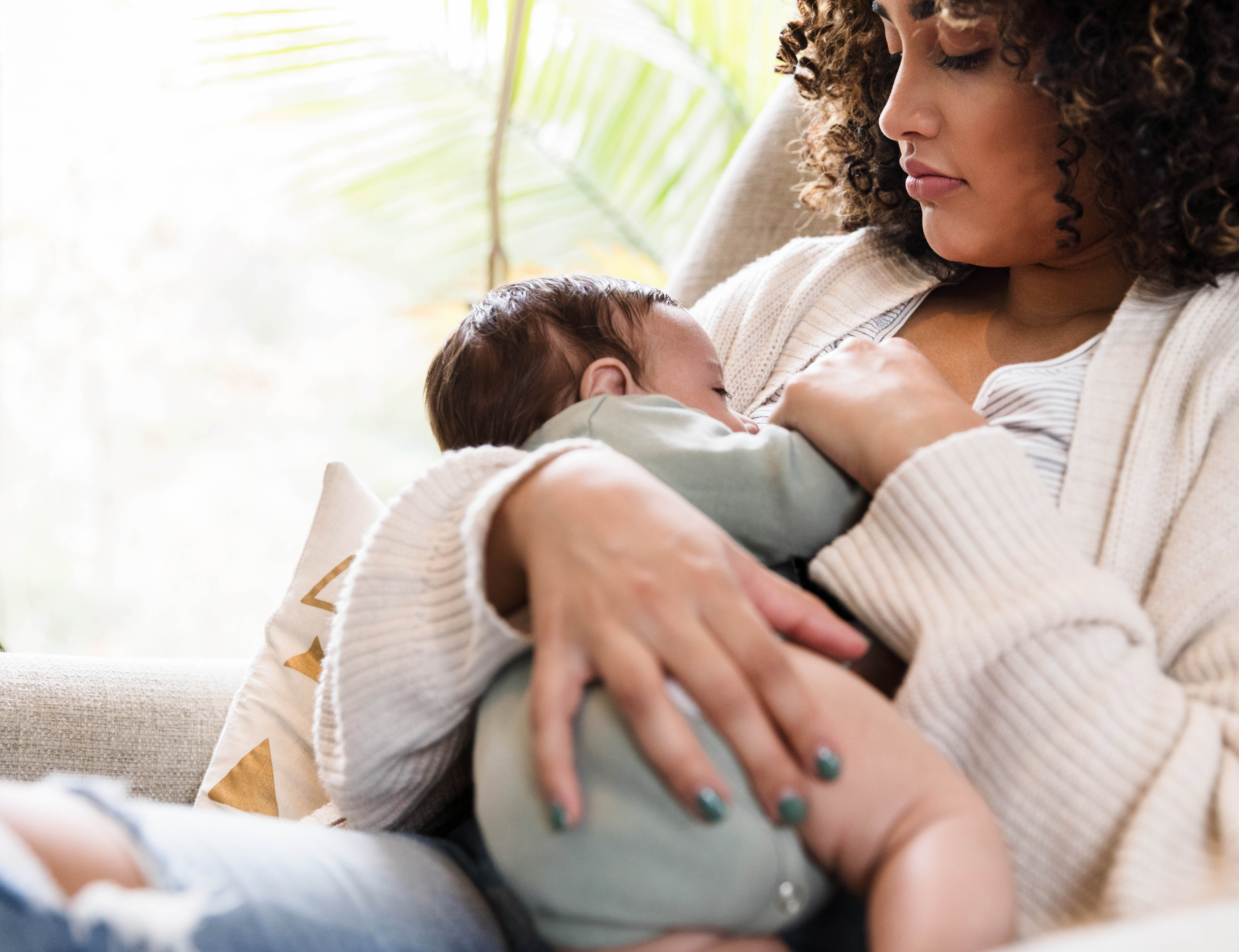 A young mother cradles her breastfeeding child. 